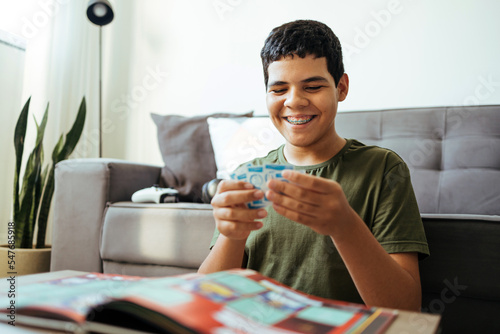 Foto Teen boy pasting stickers in collection album for world football championship