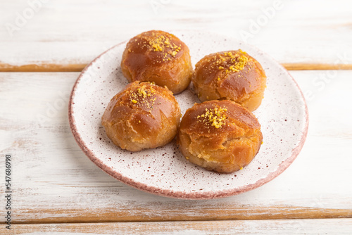 Traditional turkish dessert sekerpare with almonds and honey on white wooden, side view. photo