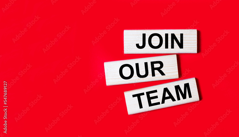 Three wooden blocks with the text JOIN OUR TEAM on a bright red background. Copy space Three wooden blocks with the text JOIN OUR TEAM on a bright red background. Copy space