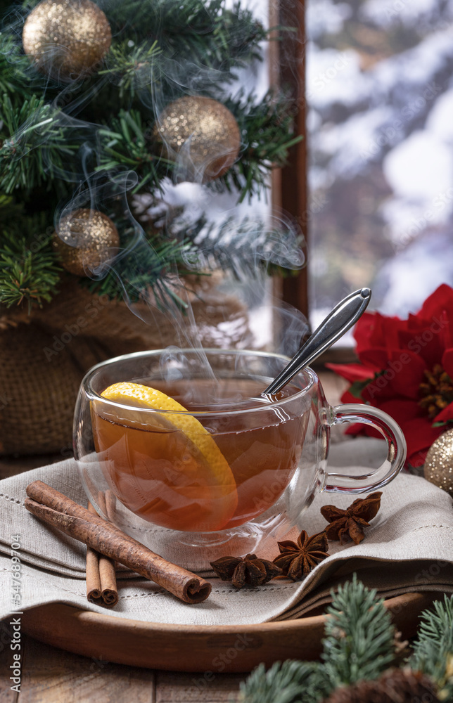 Steaming hot tea with lemmon slice with holiday decorations Steaming hot tea with lemmon slice with holiday decorations