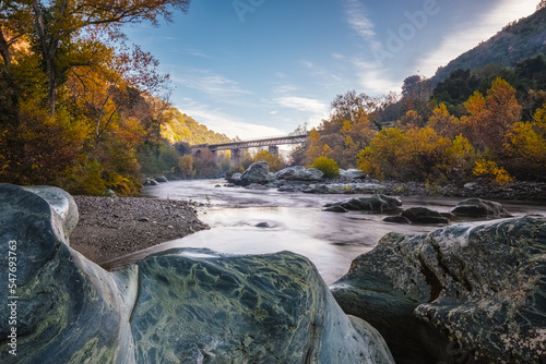 Autumn foliage and boulders by the Golo river as it passes under the Pont d'Albano railway bridge at the Torrent de Cipetto near Barchetta in Corsica photo