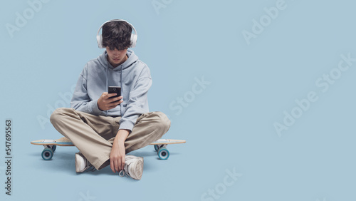 Skater sitting and using a smartphone