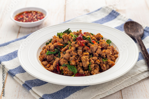 Fototapeta Naklejka Na Ścianę i Meble -  Stir-fried minced pork with holy basil leaves or pad kra pao moo, a simple-easy-delicious Thai hot dish served diners from street food carts to restaurants in Thailand.