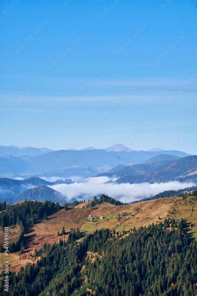 Aerial landscape photo of mountains covered with light fog. Picturesque view from above.