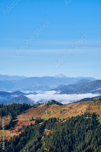 Aerial landscape photo of mountains covered with light fog. Picturesque view from above.