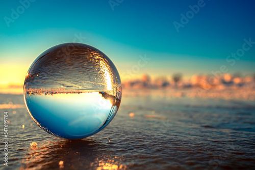 Принти на полотні River surface ripples and clouds in sky and forest captured in glass ball