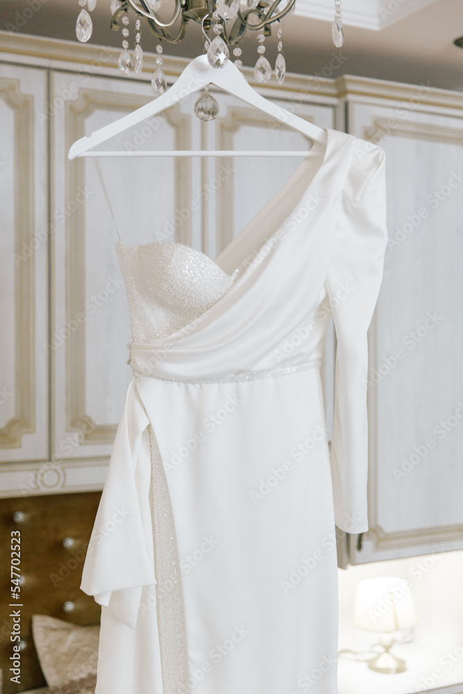 Fees for the wedding of a beautiful luxurious bride in a bathrobe with a wedding dress in a hotel, fashion portraits Fees for the wedding of a beautiful luxurious bride in a bathrobe with a wedding dress in a hotel, fashion portraits