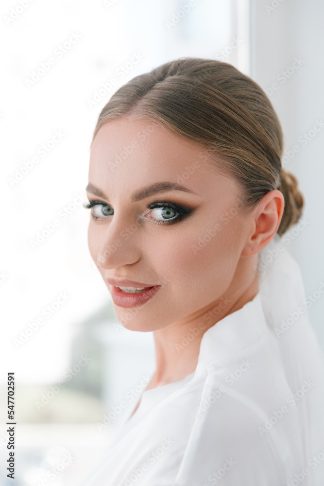 Fees for the wedding of a beautiful luxurious bride in a bathrobe with a wedding dress in a hotel, fashion portraits Fees for the wedding of a beautiful luxurious bride in a bathrobe with a wedding dress in a hotel, fashion portraits