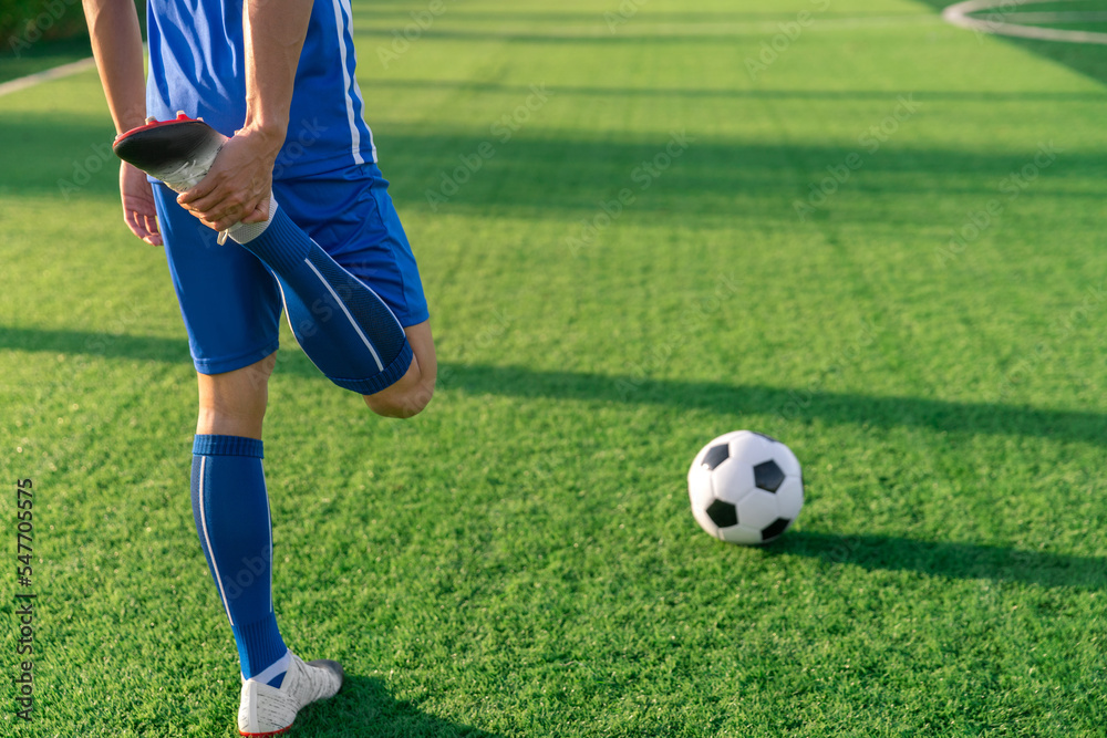 football soccer player stretching during warm up before kick ball in football match league in stadium with healthy sport concept football soccer player stretching during warm up before kick ball in football match league in stadium with healthy sport concept