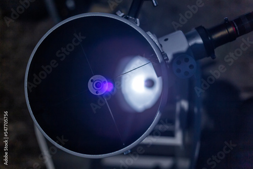 Telescope reflector of the Newtonian system. View inside. Reflection of the main mirror. Secondary mirror and spider