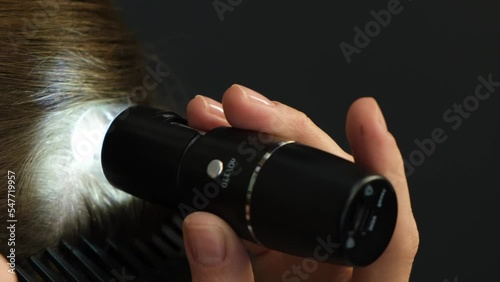 A young woman is examined by a professional trichologist. Treatment of hair loss in a clinic.