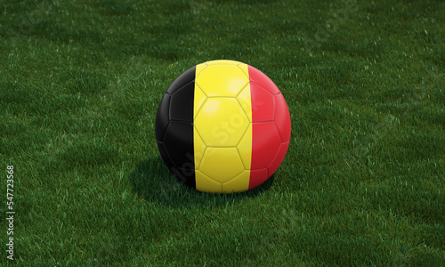 Soccer ball with Belgium flag colors at a stadium on green grasses background.