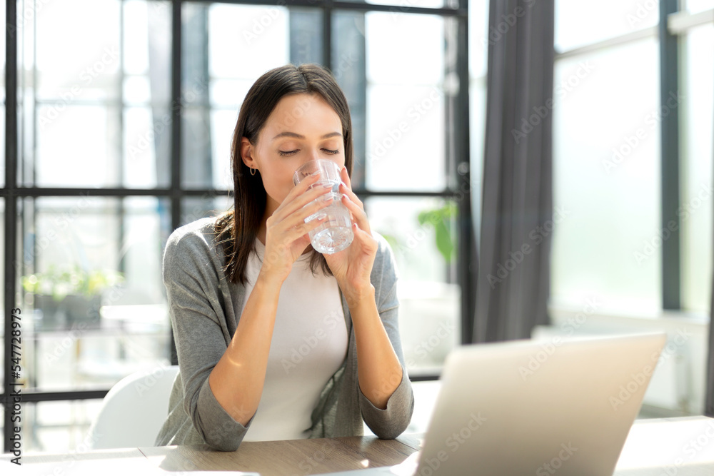 Woman drinking water after taking medicine in the office Woman drinking water after taking medicine in the office