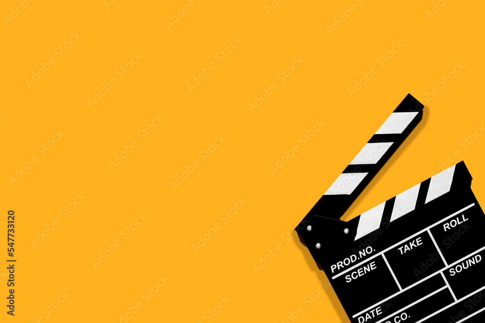 Movie clapperboard for shooting videos and movies on a orange background plenty of space for text