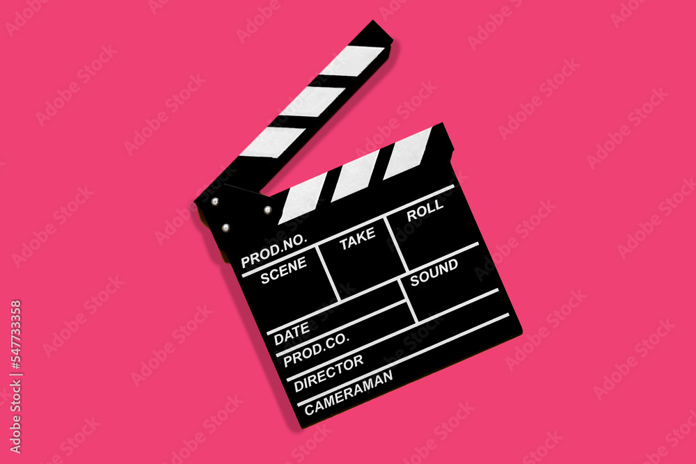 Clapperboard for shooting video footage takes on a pink background