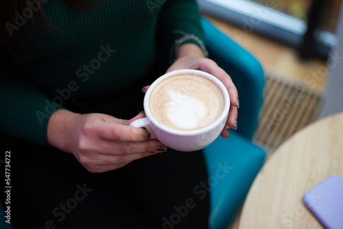 A woman with a cup of coffee in her hands