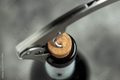 Bottle, corkscrew and cork on a black background. Close-up. Selective focus.