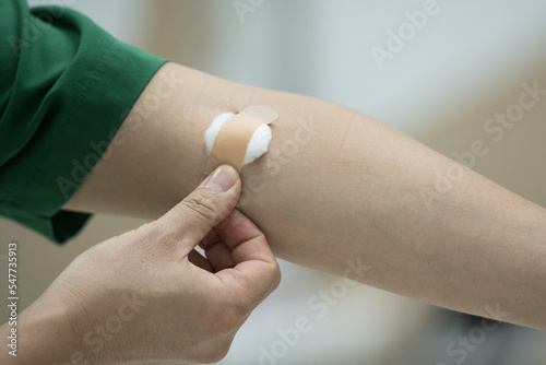 Close up patient hand push cotton after taking blood sample from a patient in the hospital.Nurse collecting blood sample for diagnosis covid-19.Blood drawing for coronavirus.