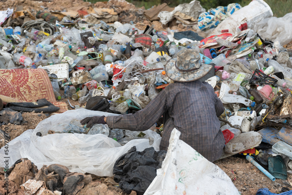Workers hands sorting garbage for recycling.View of garbage field in trash dump or open landfill, food and plastic waste products polluting in a trash dump.World environment day concept.