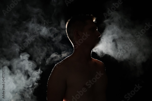 silhouette of a guy. men in the dark. smoke . steam . man in a dark room.