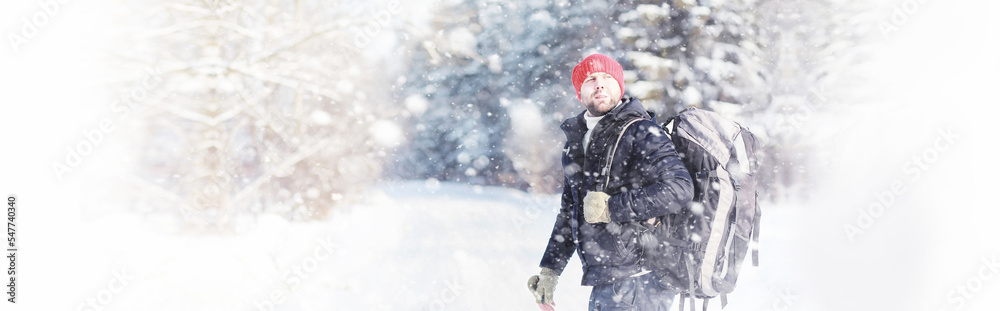 A man travels with a backpack. Winter hike in the forest. Tourist on a walk in the winter in the park. A man travels with a backpack. Winter hike in the forest. Tourist on a walk in the winter in the park.
