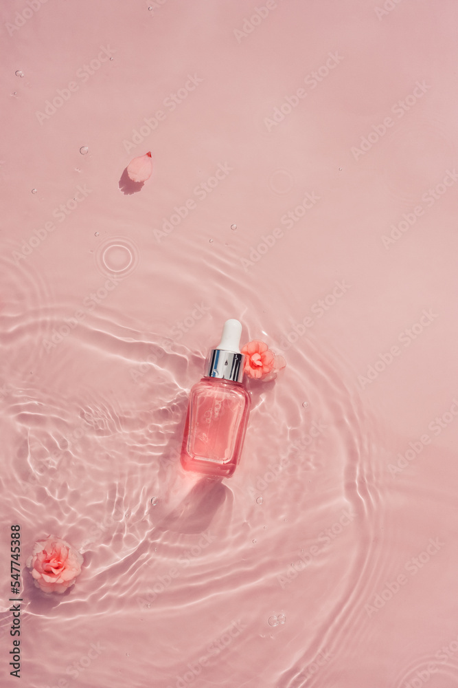 Cosmetic bottle with serum, collagen, oil in water wave and pink roses Cosmetic bottle with serum, collagen, oil in water wave and pink roses