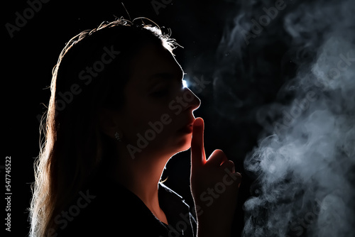 silhouette of a girl in the dark. smoke . steam . girl in a dark room.