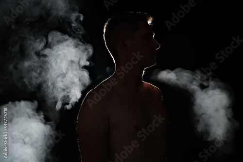 silhouette of a guy. men in the dark. smoke . steam . man in a dark room.