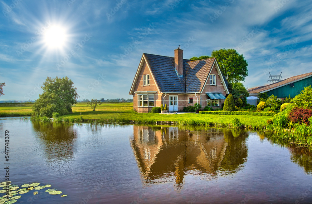 Red bricks house in countryside near the lake with mirror reflec Red bricks house in countryside near the lake with mirror reflec