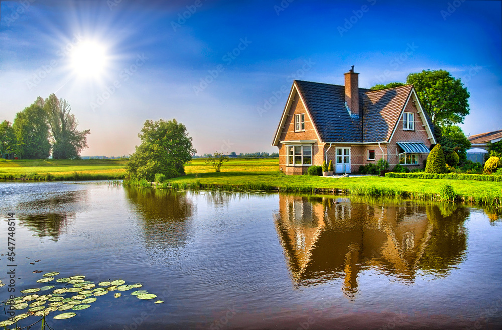 Red bricks house in countryside near the lake with mirror reflec