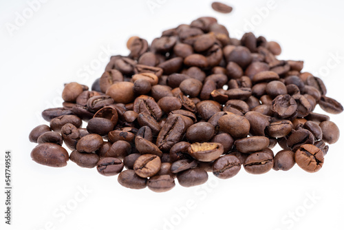 Heap of dry coffee beans isolated on white background