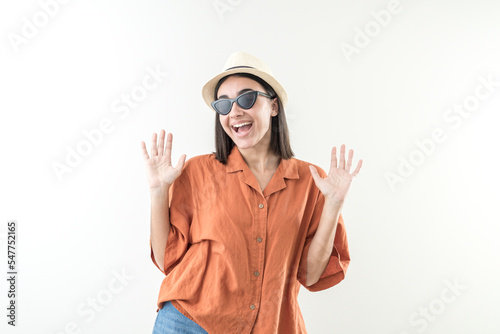 Happy young girl with cap and sunglasses raises her hands