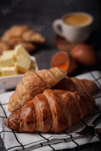 delicious croissants on parchment on a dark concrete background coppy space.