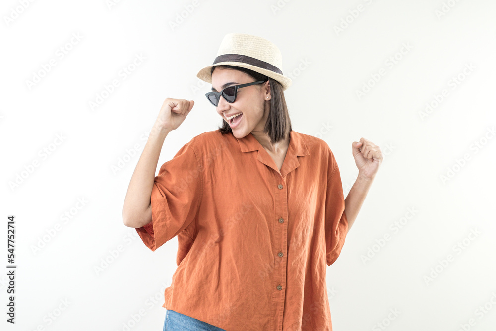 Happy young girl with cap and sunglasses raises her fists Happy young girl with cap and sunglasses raises her fists