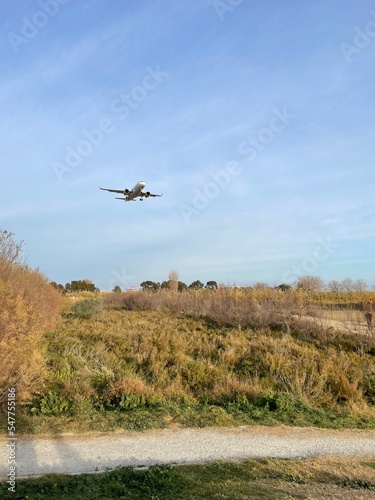 Avión despegando y sobrevolando el cielo a baja altura. Vistas desde un mirador.