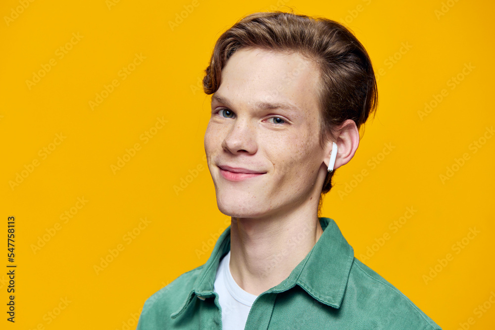 portrait of a cheerful, handsome guy in wireless headphones