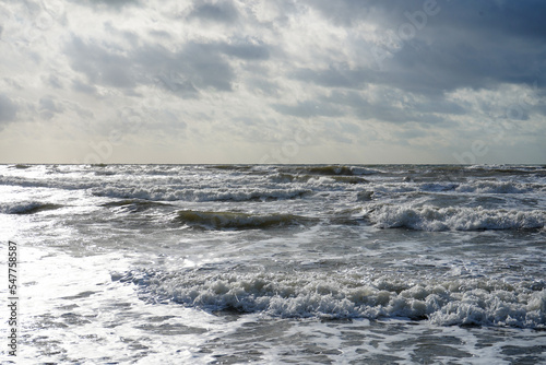 Waves crashing in the ocean with a cloudy sky