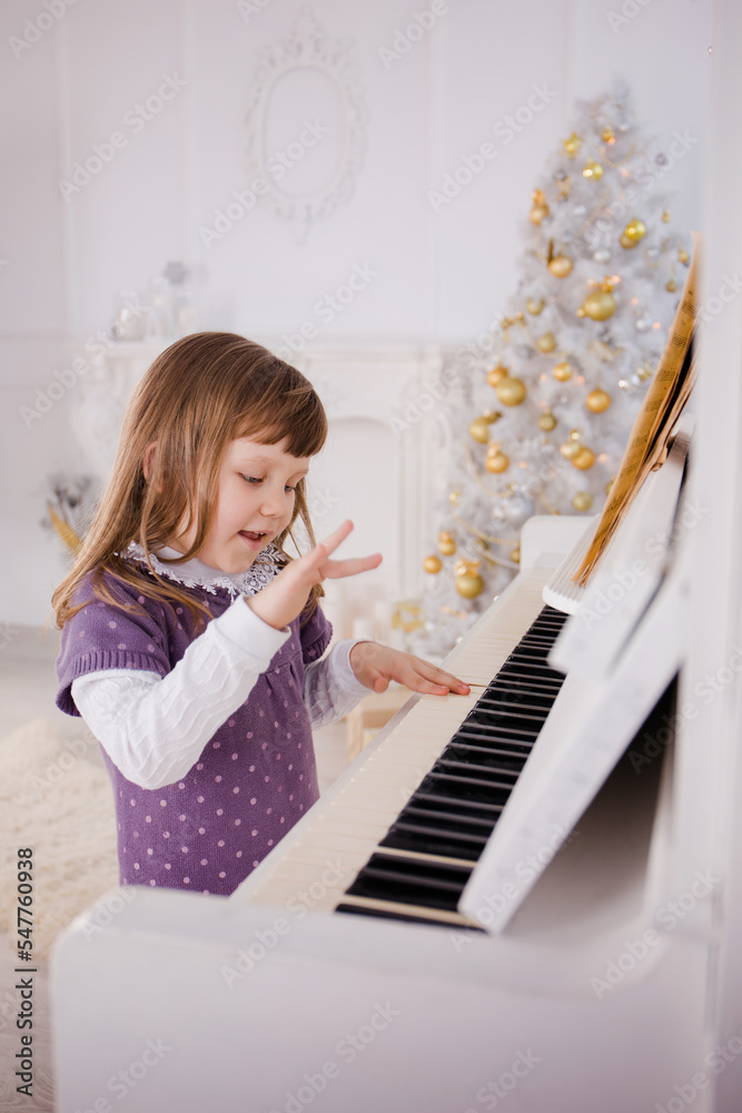 a cute little girl plays the piano and sings a New Year's song a cute little girl plays the piano and sings a New Year's song
