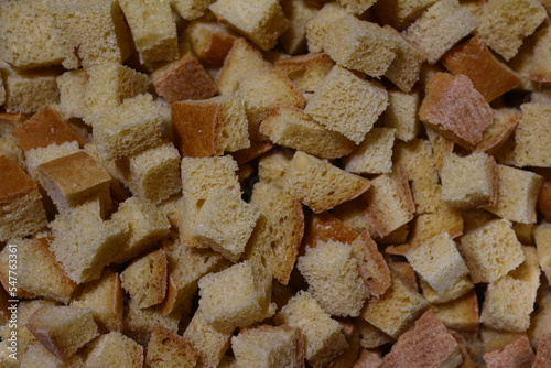 a lot of ruddy fried square croutons of white bread randomly scattered in a pile - close-up top view
