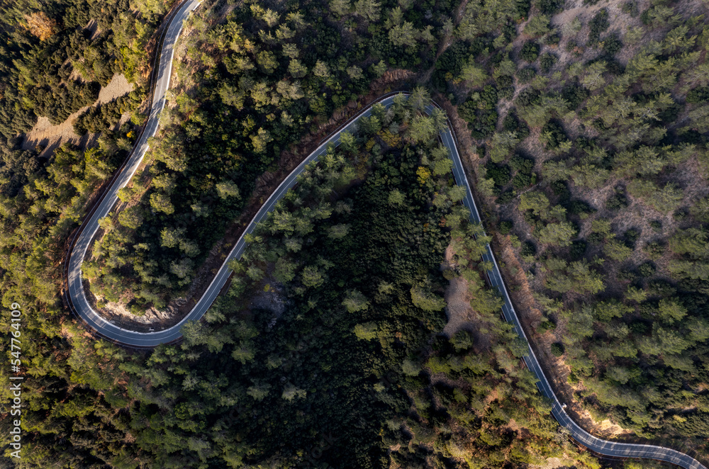 Drone aerial of mountain curved road. Adventure and challenging road trip in the forest
