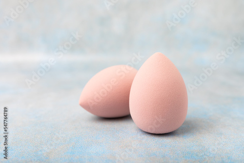 Beauty blender. Cosmetic sponge on a blue marble background. MOCAP. Sponge for applying foundation and concealer. Beauty concept. Space for text. Space for copy space.