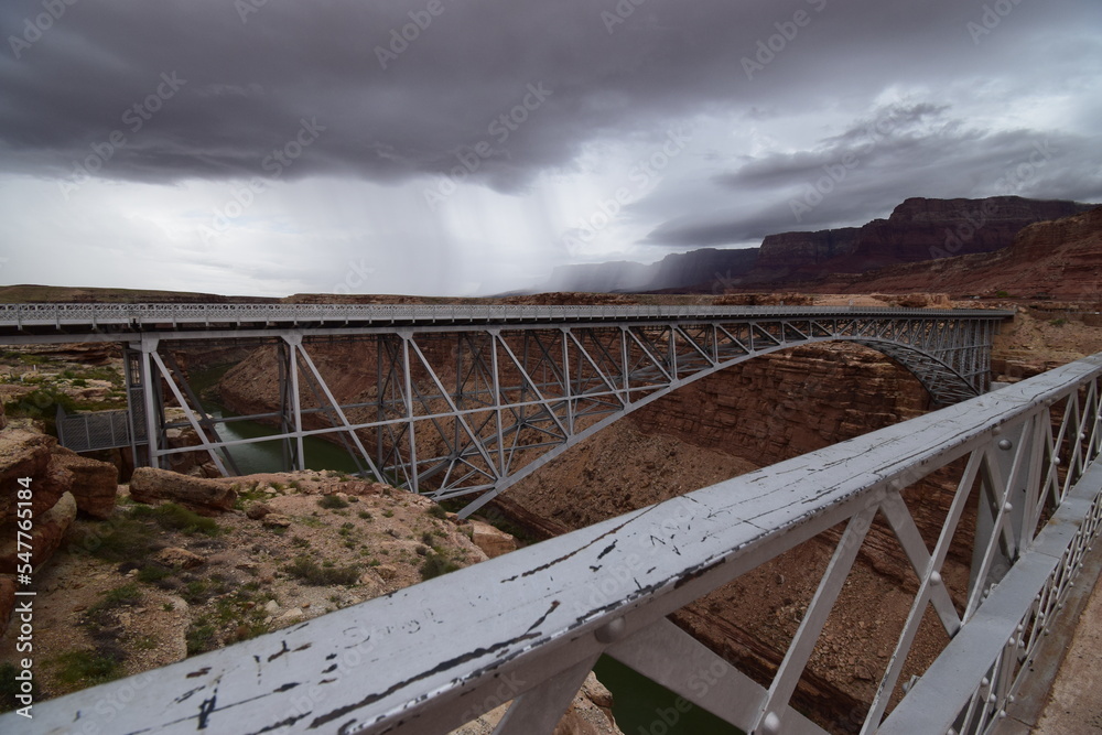 Historic Navajo bridge over Colorado river in Arizona with thunder storms clouds and rain coming in