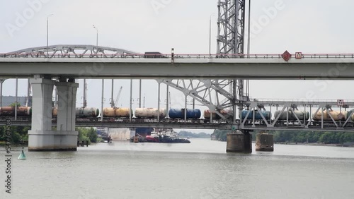 Side of freight trane with tank wagons crossing Don river on bascule bridge. Real time video. Selective focus. Railway transportation theme. photo