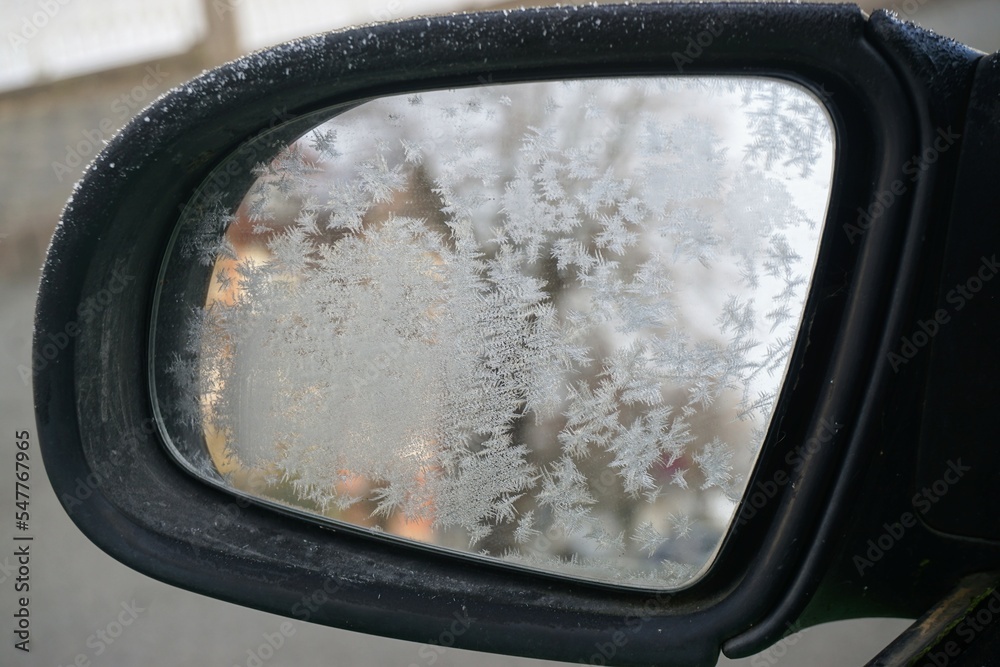 Autorückspiegel mit Eismuster bei Frost und Schnee am Morgen im Winter