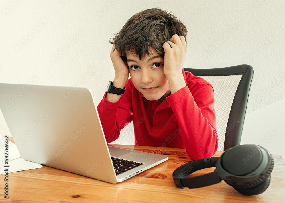 Little school boy stressed of online learning. Boy learning online class room at home, E-learning or Homeschooling education concept Little school boy stressed of online learning. Boy learning online class room at home, E-learning or Homeschooling education concept