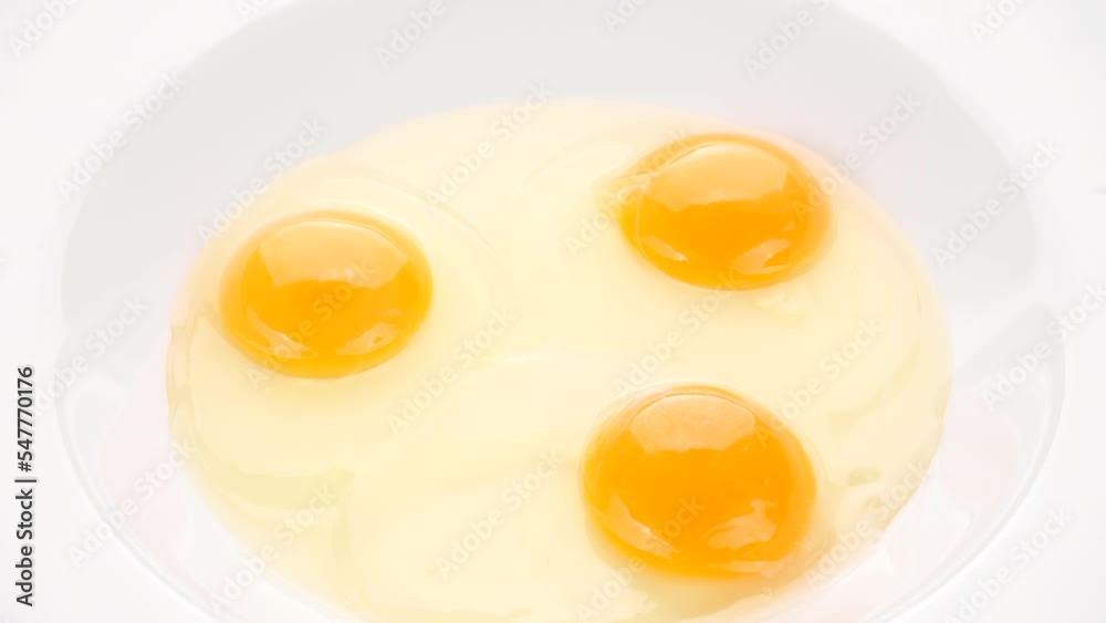 Crack eggs into a white bowl, close up Crack eggs into a white bowl, close up