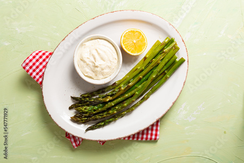 Top view of roasted green asparaguson white plate vegan food photo