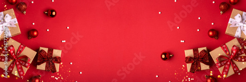 Christmas gift boxes with red balls and christmas lights on red background.