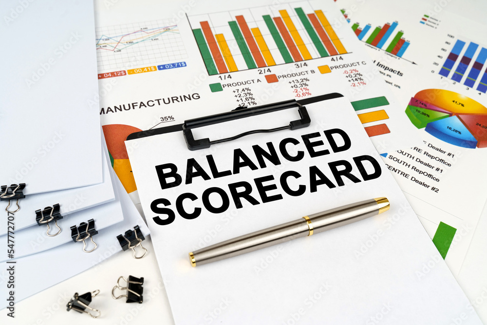 On the table among financial graphs and charts lies a tablet with the inscription - BALANCED SCORECARD On the table among financial graphs and charts lies a tablet with the inscription - BALANCED SCORECARD