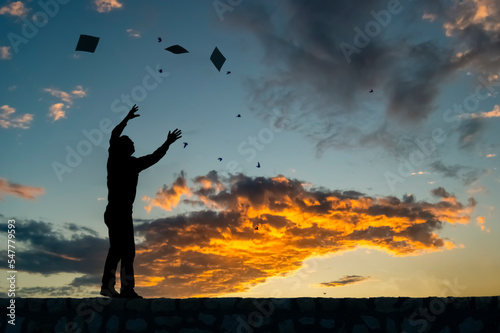 A lonely man s silhouette with his hands up at sunset